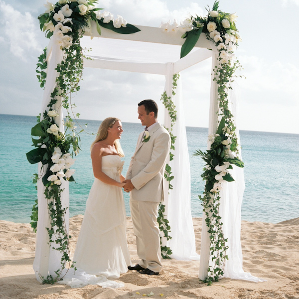 photo by New York City based wedding photographer Karen Hill - beautiful beach ceremony - white floral altar - groom in ivory suit and bride in ivory a-line style gown 